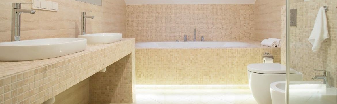 Badezimmer mit Waschtisch und Badewanne mit quadratischen Natursteinmosaikfliesen